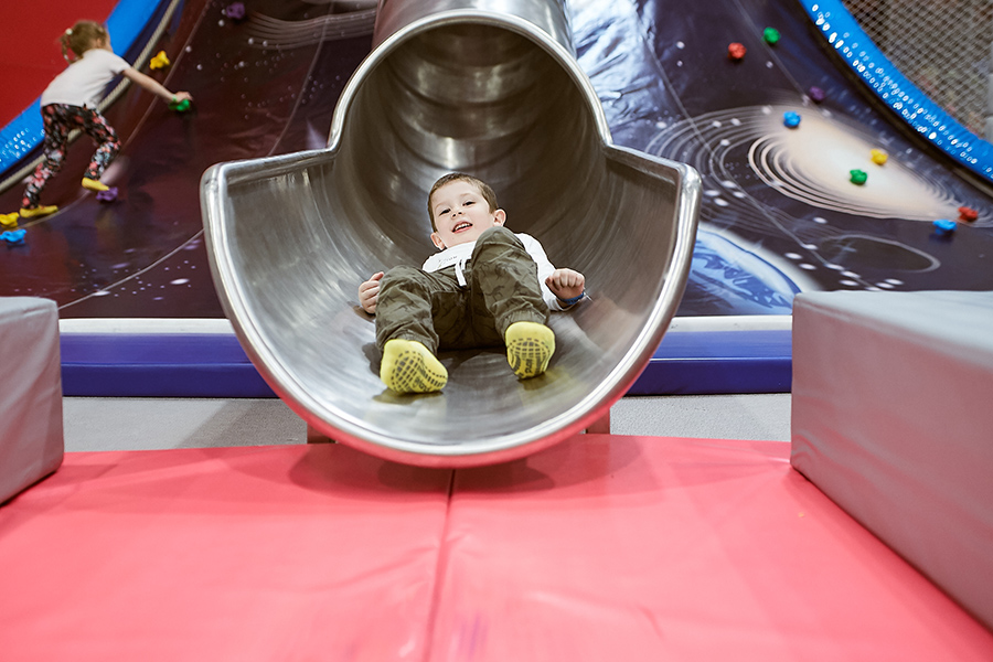 Eseményfotózás a SkyLand trambulin- és élményparkban. A fotón épp egy kisfiú érkezik le a csúszdán.